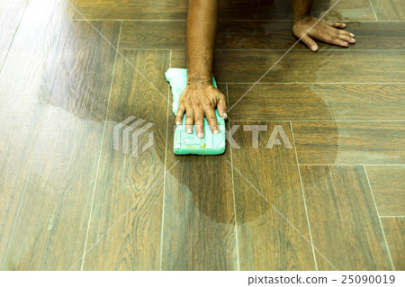 Worker cleaning floor after grouting with sponge 25090019