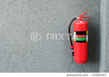 Fire extinguisher on the gray cement wall. 25090403