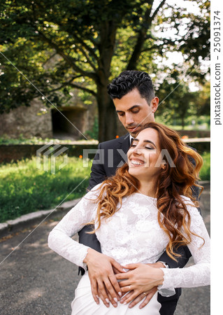 Groom puts his hands on bride's belly Groom puts his hands on bride's belly 25091374