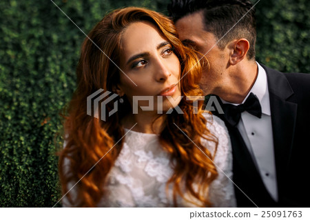 Groom hides his face in golden bride's curls Groom hides his face in golden bride's curls 25091763