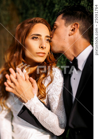 Evening sun illuminates gorgeous bride's face  25091764