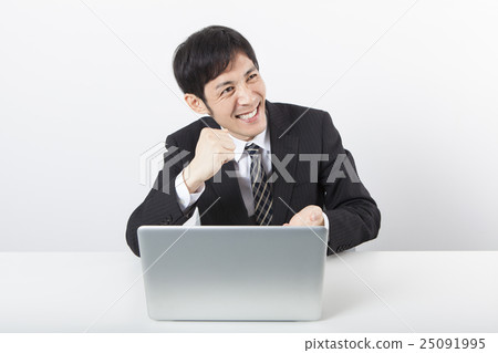 A businessman who is pleased in front of a personal computer A businessman who is pleased in front of a personal computer 25091995