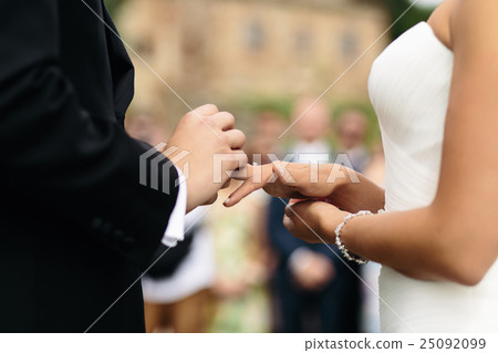 A closeup of groom's hands while he puts A closeup of groom's hands while he puts 25092099
