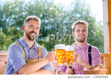 Men in traditional bavarian clothes holding mugs Men in traditional bavarian clothes holding mugs 25093093