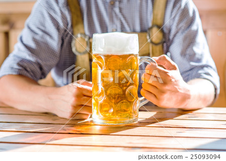 Man in traditional bavarian clothes holding mug of Man in traditional bavarian clothes holding mug of 25093094