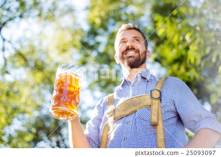 Man in traditional bavarian clothes holding mug of Man in traditional bavarian clothes holding mug of 25093097