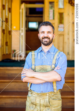 Man in traditional bavarian clothes holding mugs 25093098