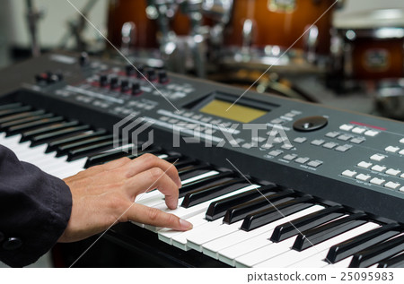 Closeup hands playing the keyboard or piano on brand music instrument background, music concept Closeup hands playing the keyboard or piano on brand music instrument background, music concept 25095983