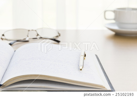 Pen put on a book with on the desk Pen put on a book with on the desk 25102193