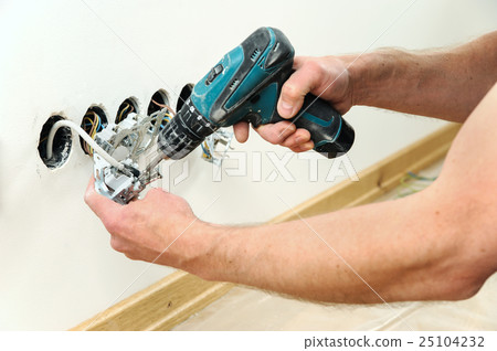 Worker installing a TV wall socket. 25104232