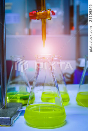 Burette filled with yellow liquid in laboratory. 25109846