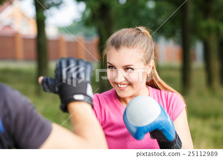 Young sporty woman training boxing with trainer Young sporty woman training boxing with trainer 25112989