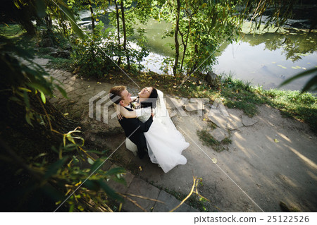 Beautiful wedding couple hugging in the park 25122526