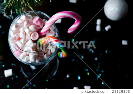 White and pink marshmallows in a glass on the dark 25129398