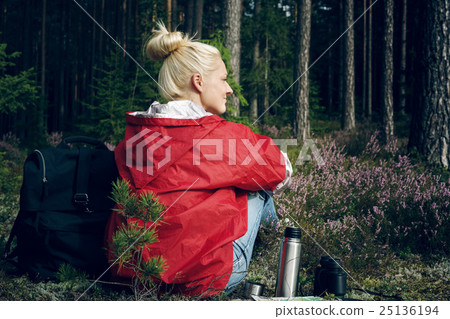 Young active woman tourist sitting in a clearing 25136194