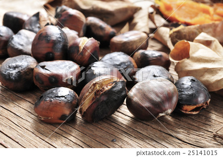 roasted chestnuts on a rustic wooden table 25141015