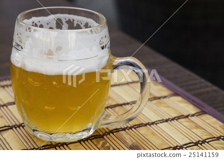 Glass mug of unfiltered weizen beer on table 25141159