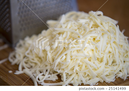 Shredded mozzarella cheese on a cutting board  25141499