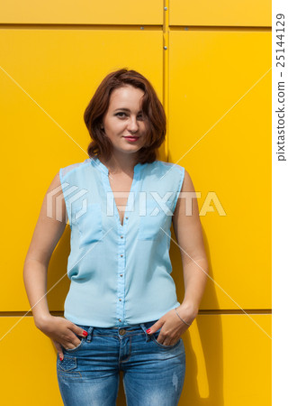 Portrait of a beautiful girl a yellow background. 25144129