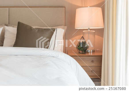 brown pillow on white modern bed with lamp brown pillow on white modern bed with lamp 25167080
