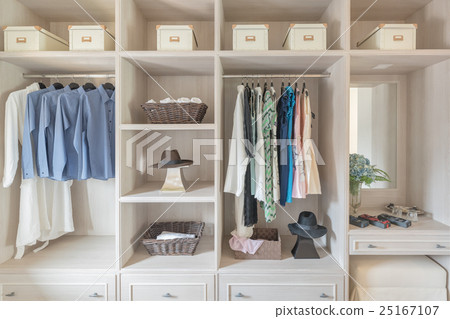 modern wooden wardrobe with clothes hanging  25167107