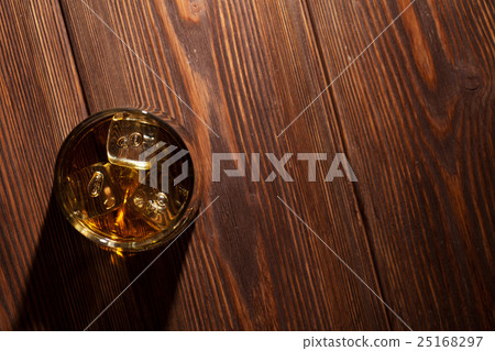 Glass of whiskey with ice on wood Glass of whiskey with ice on wood 25168297
