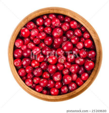 Lingonberries in a wooden bowl over white 25169680