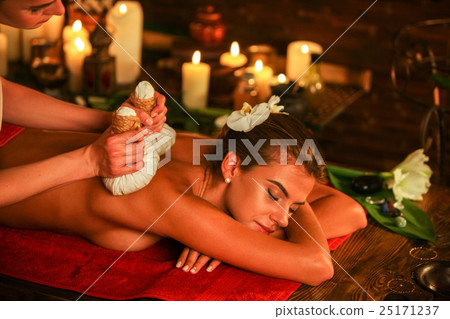 Young woman have hot poultice massage in spa salon Young woman have hot poultice massage in spa salon 25171237
