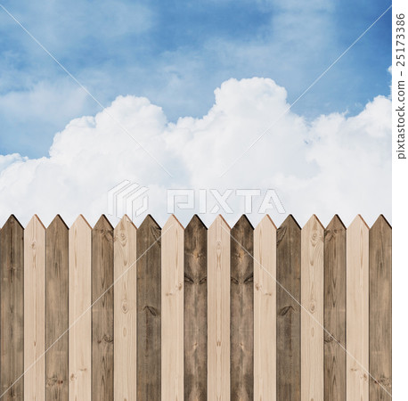Wooden picket fence with blue sky and clouds 25173386