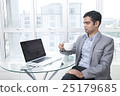 Businessman using laptop holding coffee cup  25179685