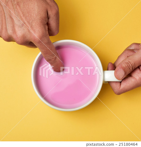 man soaking his finger in a pink milkshake 25180464
