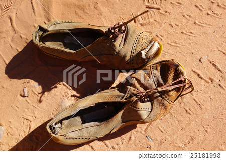 old pair of shoes on sand old pair of shoes on sand 25181998