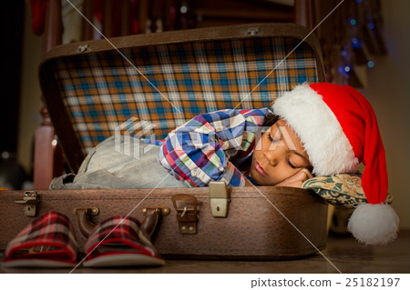 Boy's Christmas nap inside suitcase. 25182197