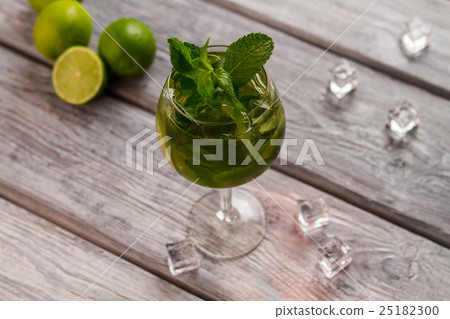 Wineglass with beverage and limes. 25182300