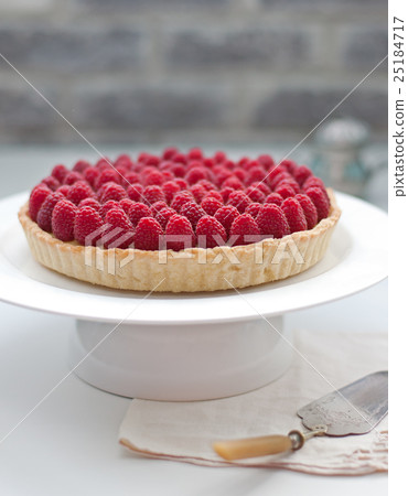 Raspberry tart on a white plate Selective focus 25184717