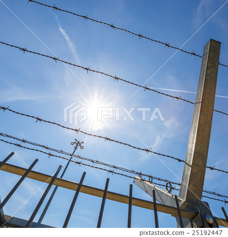 barbed wire and sun on blue sky background barbed wire and sun on blue sky background 25192447