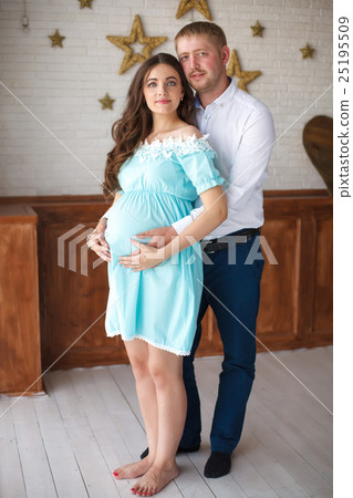 Pregnant woman and her husband touching belly with Pregnant woman and her husband touching belly with 25195509