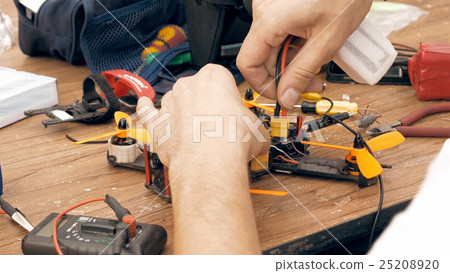 Man assembling FPV drone using tools 25208920