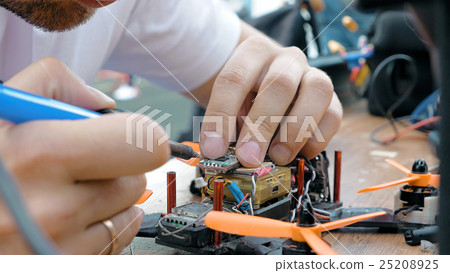 Man's hands welding details assembling FPV drone Man's hands welding details assembling FPV drone 25208925