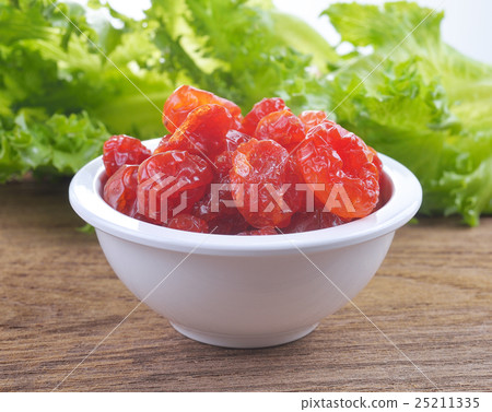Sun-dried cocktail tomatoes on wood background Sun-dried cocktail tomatoes on wood background 25211335