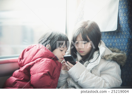 Asian children playing game on mobile together Asian children playing game on mobile together 25219004