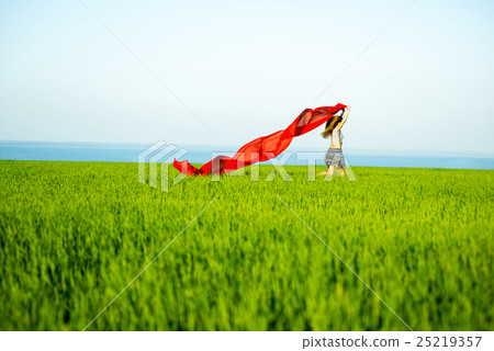 Young happy woman in wheat field with fabric 25219357