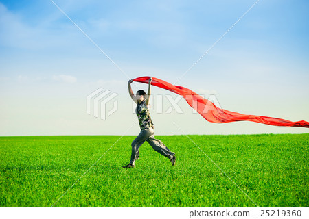 Beautiful young woman jumping on a green meadow 25219360