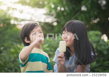 Cute Asian child eating an ice cream outdoors 25219456