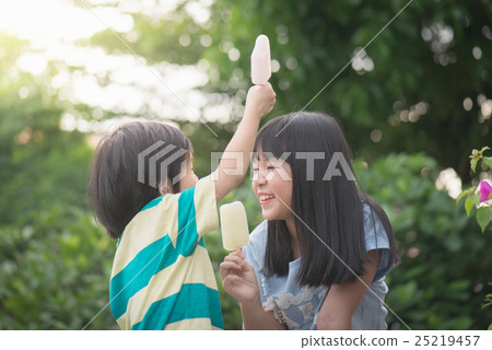 Cute Asian child eating an ice cream outdoors 25219457