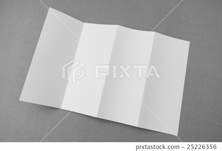Four - fold white template paper on gray background . 25226356