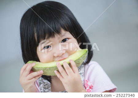 Lovely Asian child girl eating delicious melon 25227340
