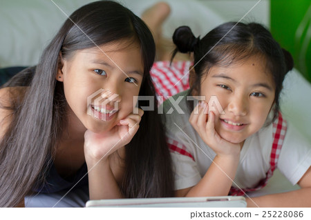 Close up of Asian child using tablet together 25228086