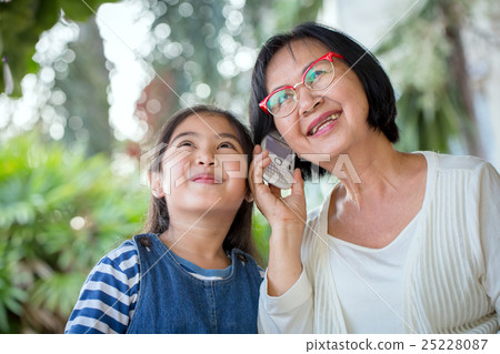 Asian girl calling mobile phone with her grandmom 25228087