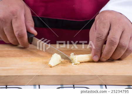 Chef cutting baby corn 25234795